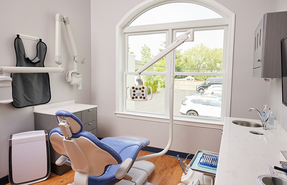 Dental exam room in Revere dental office with window showing trees and parking lot