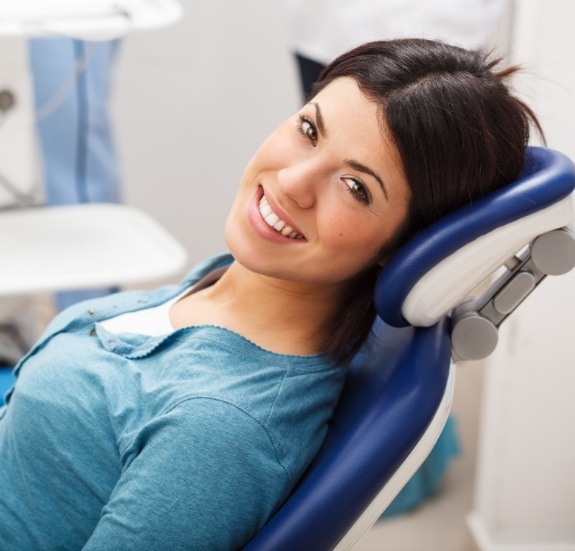 Smiling woman leaning back in dental chair