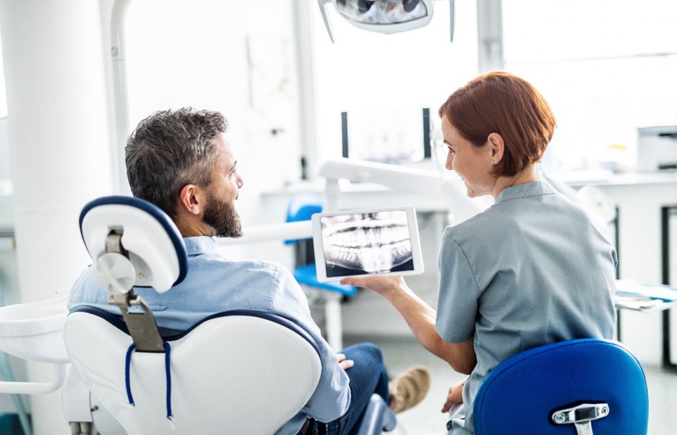 a dentist speaking with a patient about their X-rays