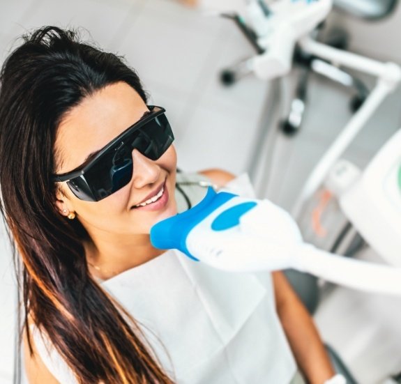 Woman receiving professional teeth whitening in dental office