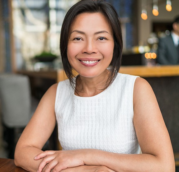 Smiling woman in white sleeveless blouse