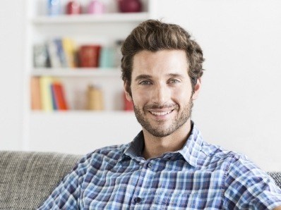 Man in plaid shirt sitting on couch