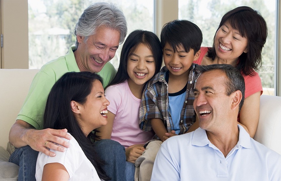 Two kids smiling with their parents and grandparents after visiting family dentist in Revere