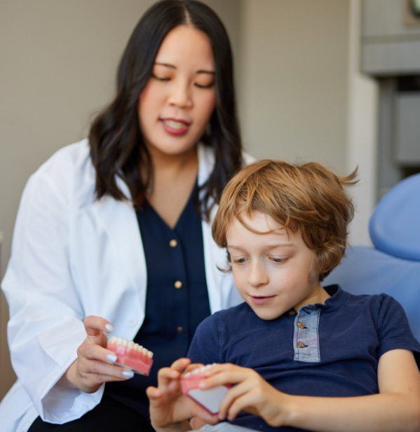 Dentist showing a child patient a model of the teeth