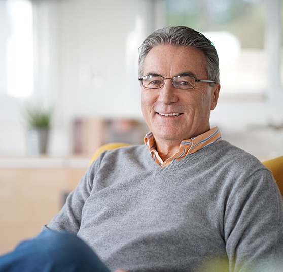 Older man smiling after dental implant care in Revere