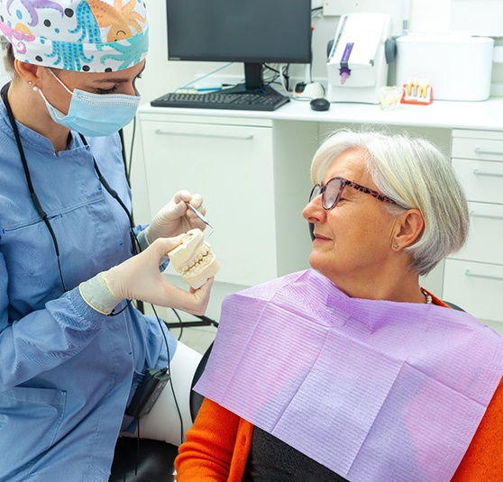 Dentist discussing full arch implant restorations with a female patient