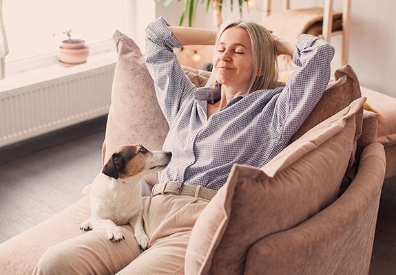 Woman relaxing on a couch with her dog