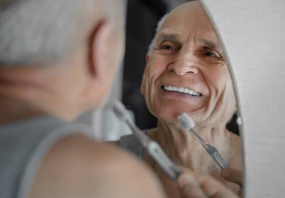 Older man brushing his teeth
