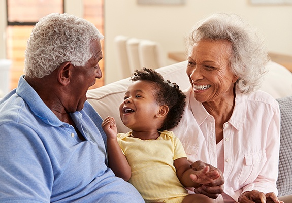 Grandparents smiling with their grandchild