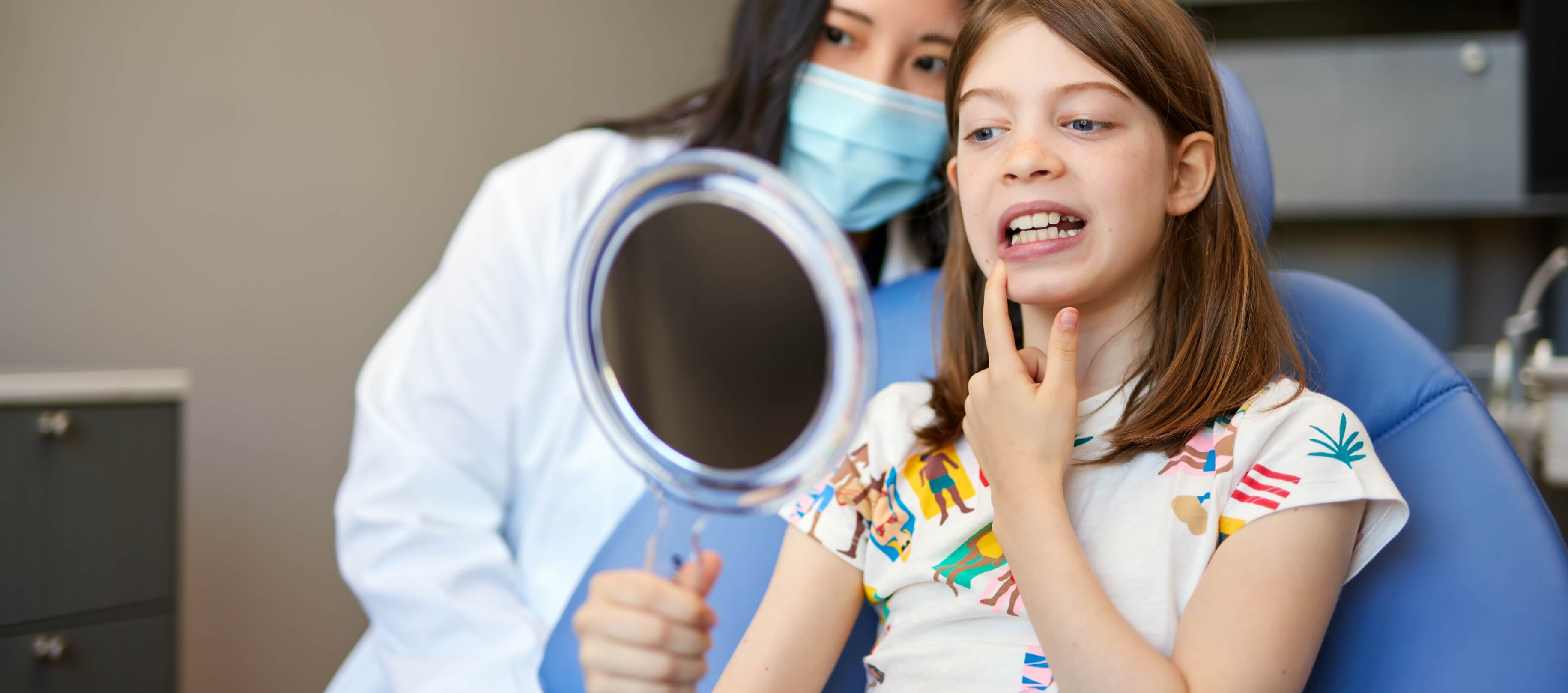 Doctor Ma showing a child dental patient their smile in mirror