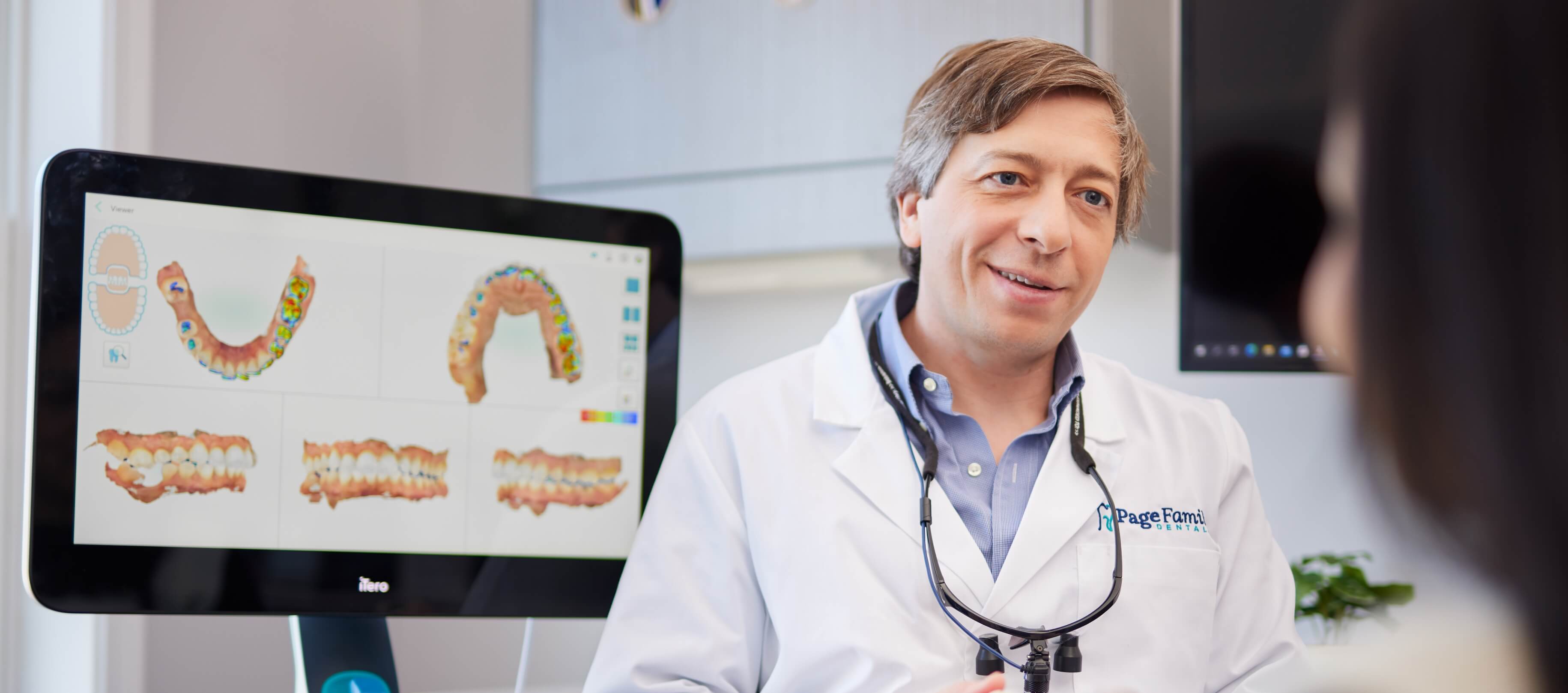 Doctor Page talking to a dental patient with computer monitor in background