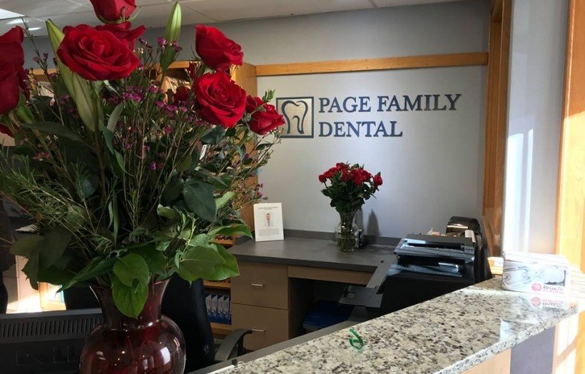 Two vases with red roses on front desk