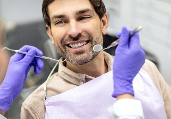 Man having his teeth and gums checked by dentist