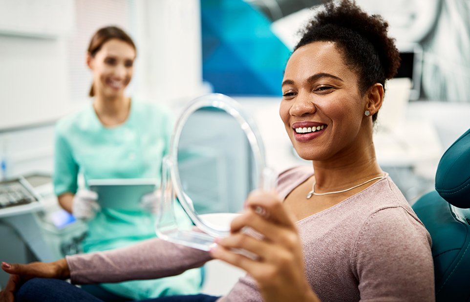 Dental patient admiring her smile in mirror